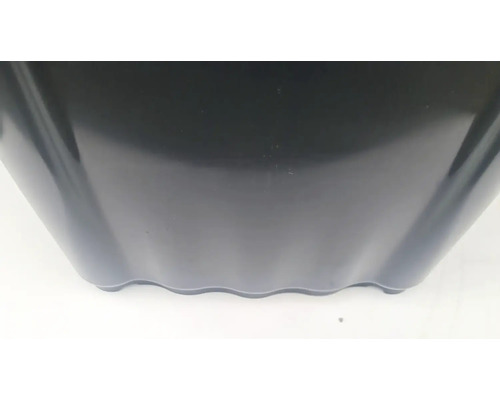 Detailný pohľad na čierny plastový kvetináč s vlnitým spodným okrajom.