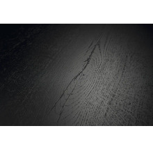 Detailný pohľad na tmavý povrch podlahovej krytiny s textúrou dreva a viditeľným uzlom.