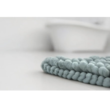 Detailný záber na mäkkú kúpeľňovú predložku z mikrovlákna s žinylkovou štruktúrou v kúpeľni pred vaňou.