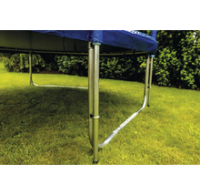 Detailný pohľad na rám trampolíny s kovovými nohami v tvare U na trávniku v záhrade.