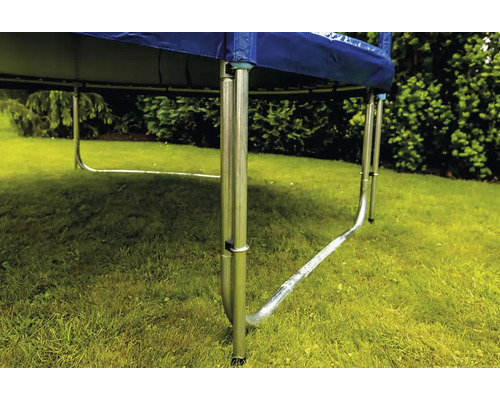 Detailný pohľad na rám trampolíny s kovovými nohami v tvare U na trávniku v záhrade.