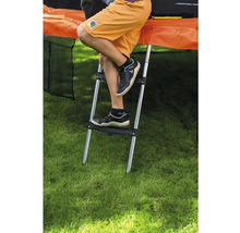 Kovový rebrík na trampolínu s dvoma plastovými stupienkami, pripevnený k trampolíne v záhrade.