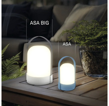 Dve moderné LED lampy ASA BIG a ASA na drevenom stole, atmosférické vonkajšie osvetlenie s rastlinami a pohovkou v pozadí.