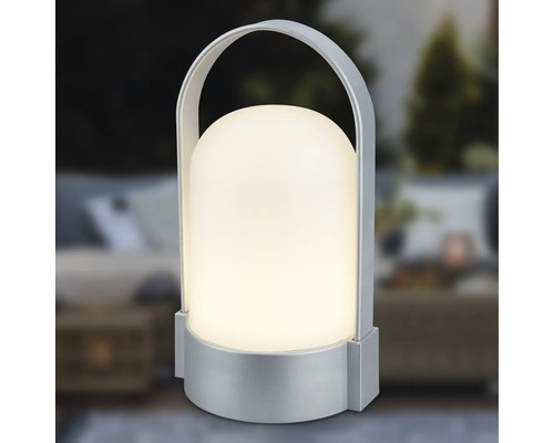 Prenosná stolná LED lampa so strieborným podstavcom a držadlom, tienidlo v tvare kupoly, teplé biele svetlo.