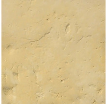 Štruktúrovaný povrch z pieskovo žltého prírodného kameňa alebo omietky s malými jamkami.