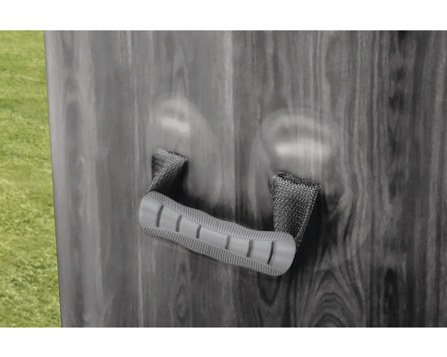 Rukoväť s tkanými pútkami na stene v dekore dreva.