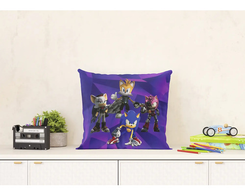 Dekoračný vankúš Sonic Prime na komode s rastlinou, organizérom, knihami a autíčkom vo svetlom prostredí.