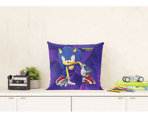 Dekoratívny vankúš s motívom a logom Sonic Prime na bielej komode vo svetlej, organizovanej detskej izbe s rastlinami a hračkami.
