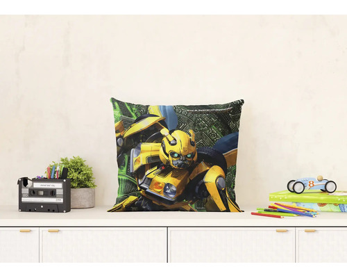 Štvorcový dekoratívny vankúš s postavou Transformers Bumblebee na bielej komode v presvetlenej detskej izbe.