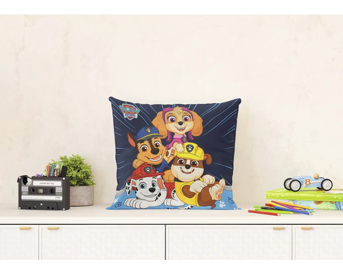 Svetlá a usporiadaná scéna so štvorcovým dekoratívnym vankúšom Paw Patrol s postavičkami Marshall, Chase, Rubble a Skye na písacom stole.