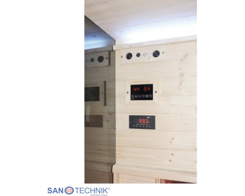 Ovládanie sauny Sanotechnik s digitálnym displejom pre teplotu a čas a s rádiom na drevenej stene.