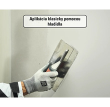 Nanášanie stierky na stenu pomocou hladidla.