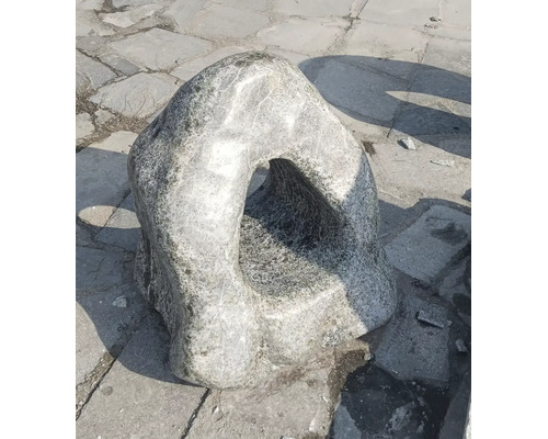 Veľký záhradný kameň s prirodzeným otvorom ako dekoratívny prvok do exteriéru.
