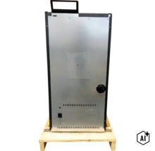 Zadná strana peletových kachlí na drevenej palete s rukoväťou a ventilačnými otvormi. (Image AI modified or generated)