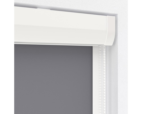 Detailný pohľad na sivú roletu s bielou kazetou a ovládacou retiazkou.