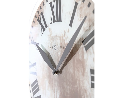 Detail nástenných hodín s rímskymi číslicami a logom Nextime.