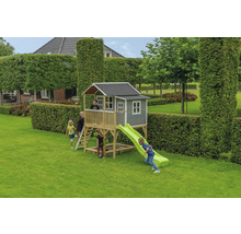 Hrací domček so šmýkačkou a pieskoviskom v záhrade s hrajúcimi sa deťmi