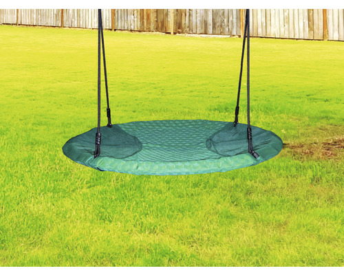 Okrúhla zelená hojdačka s čiernymi lanami v záhrade.