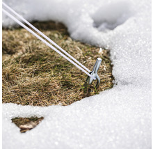 Kolík s napínacím lankom v snehu na trávniku