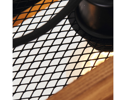 Detailný záber lampy s kovovou mriežkou a dreveným prvkom