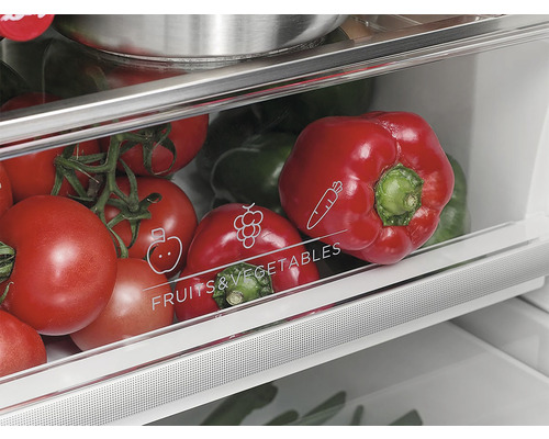 Zásuvka na zeleninu v chladničke plná paprík a paradajok