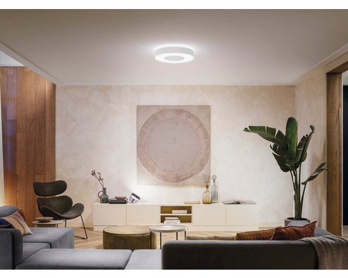 Obývacia izba s moderným vybavením a okrúhlym stropným svietidlom