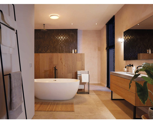 Kúpeľňa s vaňou, umývadlom, zrkadlom a držiakom na uteráky pre modernú atmosféru