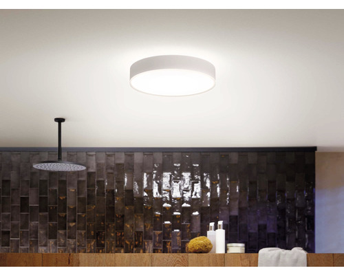 Moderná kúpeľňa so stropným svietidlom, sprchou a úložným priestorom