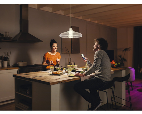 Závesná lampa nad jedálenským stolom v modernej kuchyni s dvoma ľuďmi