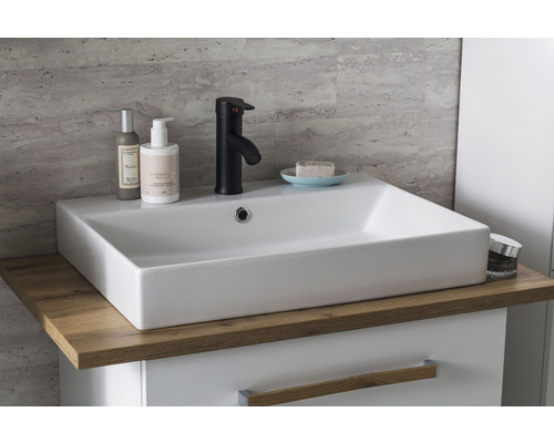 Umývadlo v kúpeľni s batériou, mydlom a kozmetickými produktmi