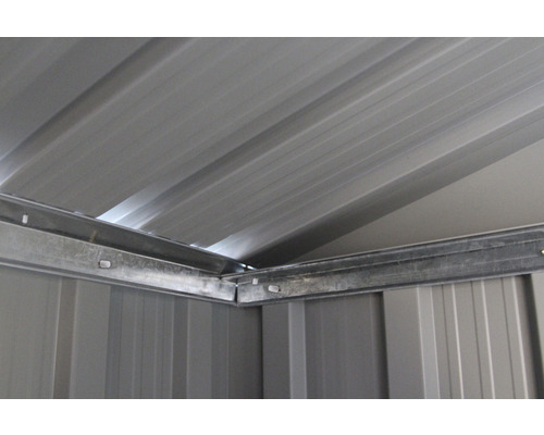 Vnútorný pohľad na kovový záhradný domček so strechou a rohovými spojmi.