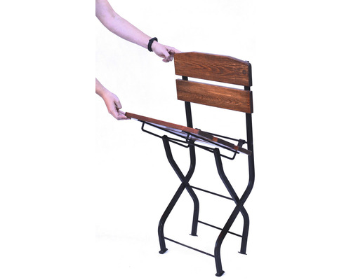 Skladacia záhradná stolička s dreveným operadlom a kovovým rámom pri používaní