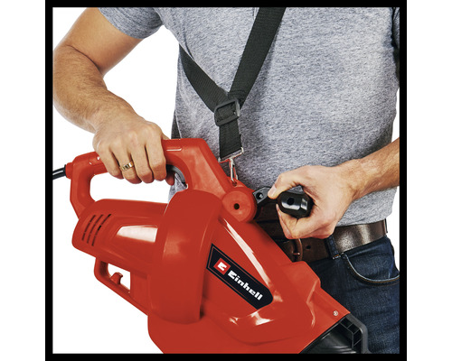 Osoba obsluhuje vysávač lístia s popruhom.