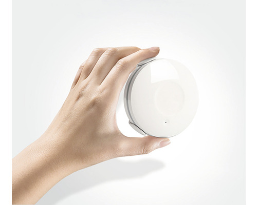 Ruka drží okrúhly detektor pohybu.