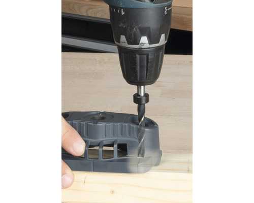 Vŕtačka vŕta do dreva pomocou vŕtacej šablóny.