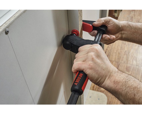 Osoba používa rohovú svorku na upevnenie obrobku.