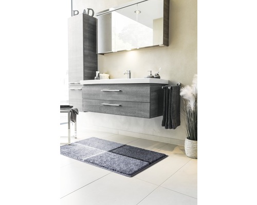 Kúpeľňa s umývadlovou skrinkou, zrkadlovou skrinkou, uterákom a kúpeľňovým kobercom