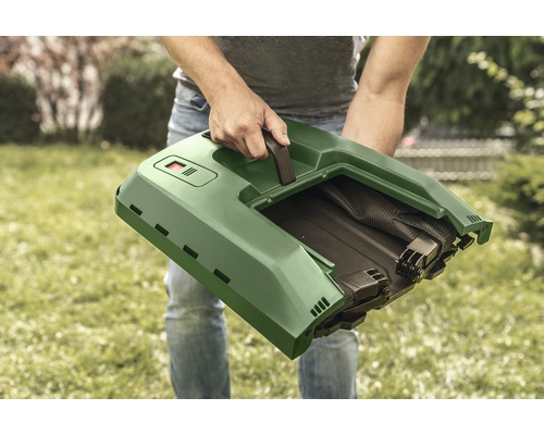 Osoba drží kôš na trávu pre kosačku na trávu