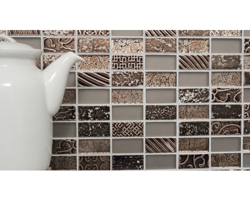 Mozaikové dlaždice s ornamentmi a biela kanvica na čaj