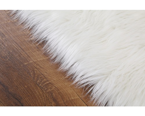 Detailný pohľad na biely koberec na drevenej podlahe