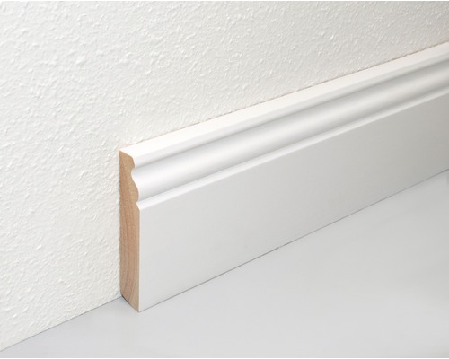 Biela drevená podlahová lišta na stene