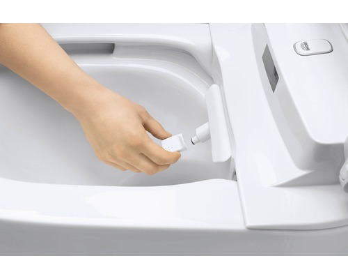 Osoba vymieňa trysku sprchovacieho záchodu.