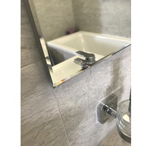 Detail kúpeľňového zrkadla s umývadlom a batériou