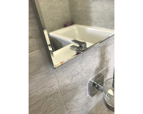 Detail kúpeľňového zrkadla s umývadlom a batériou