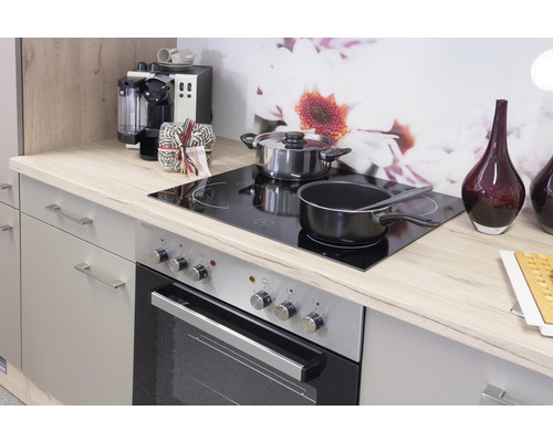 Kuchynská scéna s kachľami, varnými doskami, hrncami a kuchynskými potrebami na svetlej pracovnej doske