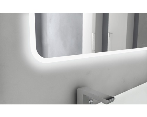 Osvetlené zrkadlo nad umývadlom v kúpeľni.