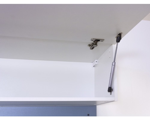 Vnútorný pohľad na bielu kuchynskú skrinku s pántmi a plynovou pružinou