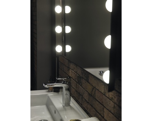 Umývadlo v kúpeľni s batériou a osvetleným zrkadlom v dizajne tehál