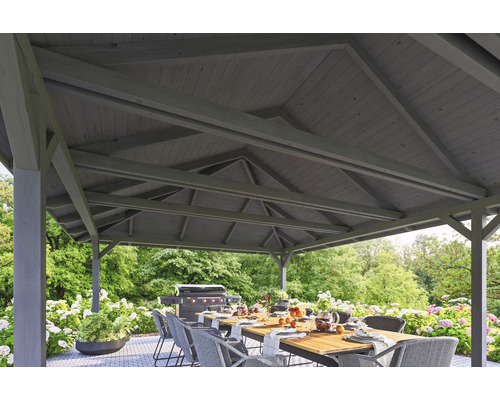 Pergola s drevenou strechou, jedálenský stôl a gril v záhrade