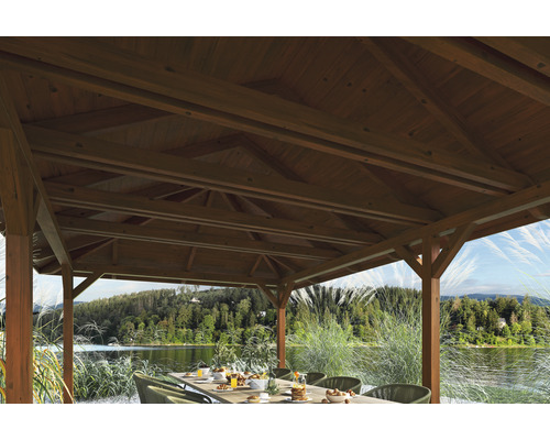 Drevený altánok s prestretým stolom a výhľadom na jazero